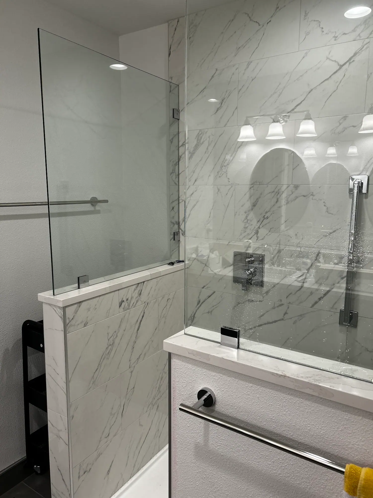 Marble-look shower with a glass panel