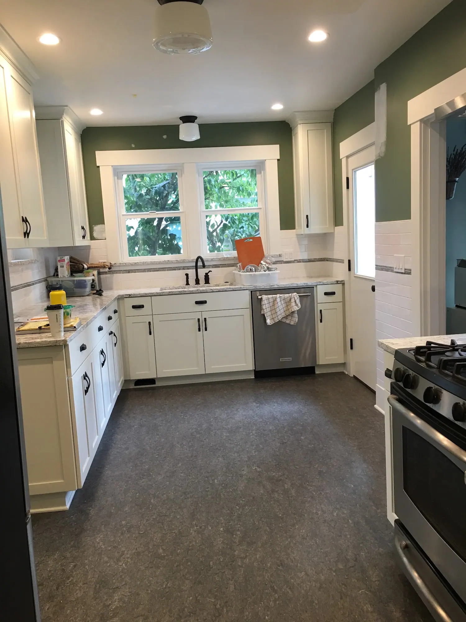 Kitchen with white cabinets and green walls